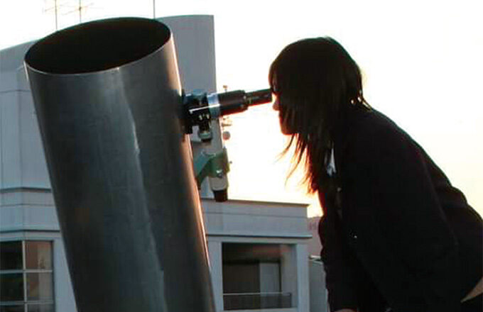 大型望遠鏡を覗く高校生